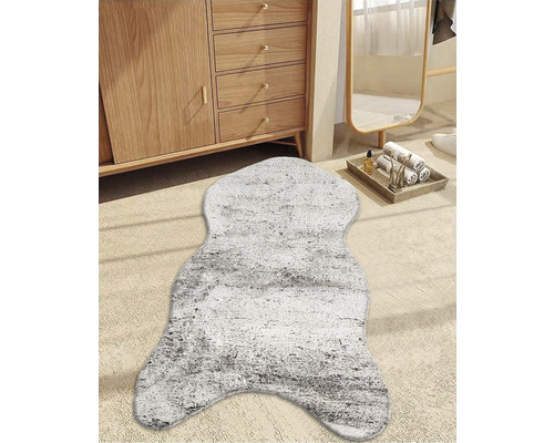 Dekorativer Teppich in Fellform vor einem Holzschrank und einem Spiegel