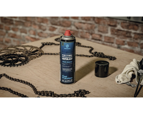 Fahrradketten-Reinigungsspray auf einem Holztisch mit Fahrradkette und Ritzel