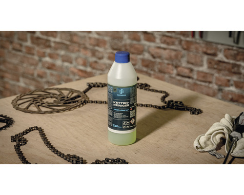 Flasche Kettenreiniger mit Ketten und Werkzeugen auf einem Tisch