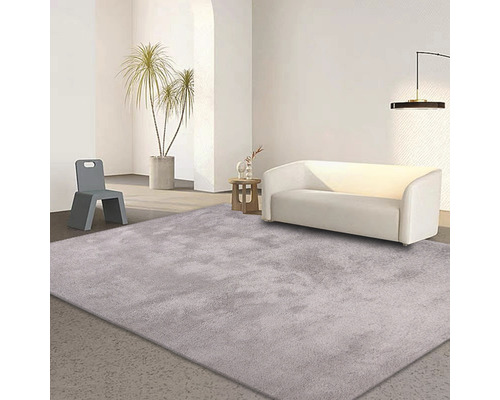 Helles Wohnzimmer mit Teppich, Sofa und Stuhl