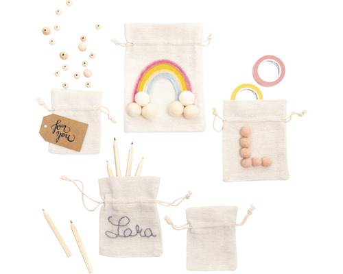 Mehrere Baumwollbeutel mit Kordelzug, verziert mit Regenbogen, Namen, Buchstaben und Geschenkanhänger, zusammen mit Holzperlen, Stiften und Klebeband
