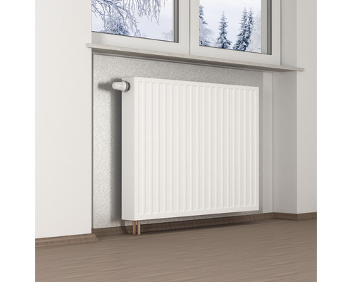 Weißer Heizkörper an Wand mit Fenster im Hintergrund