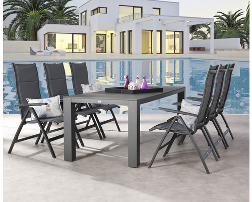 Gartentisch mit Stühlen vor Pool und Haus