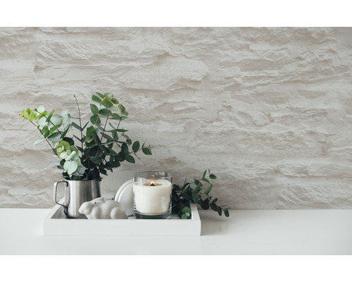 Dekorative Szene mit Kerze, Eukalyptus und Steinwand