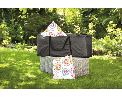 Schwarze Tragetasche mit Kissen und Gartenmöbeln im Freien