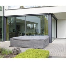 Abgedeckte Gartenmöbel auf einer Terrasse vor einem Haus