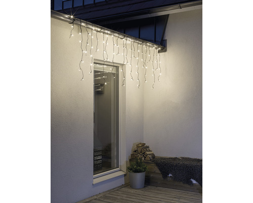 Außenansicht eines Hauses mit beleuchteter Eisregenlichterkette über einem Fenster