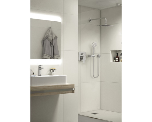 Helles Badezimmer mit Waschbecken, Spiegel, Handtuch und Dusche