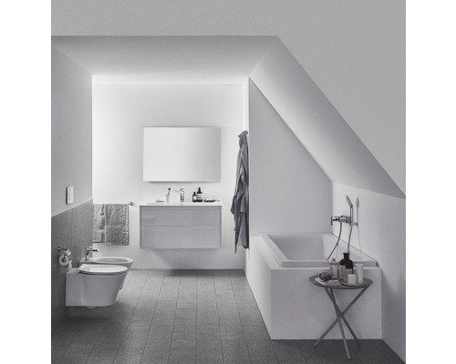 Badezimmer mit Badewanne, Waschtisch, Spiegel und Bidet unter Dachschräge