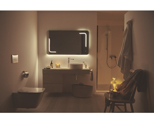 Badezimmer mit beleuchtetem Spiegel, Waschtisch, Toilette und Dusche für eine helle und geräumige Atmosphäre.