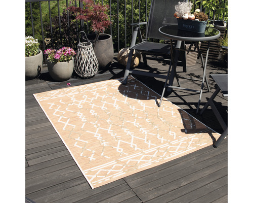 Außenbereich mit einem rechteckigen Teppich mit geometrischem Muster, Möbeln und Pflanzen auf einem Balkon