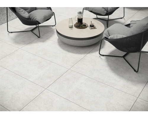 Helles, gefliestes Wohnzimmer mit Sesseln und Tisch