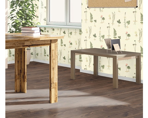 Raumansicht mit Holztisch, Schreibtisch und floral gemusterter Tapete