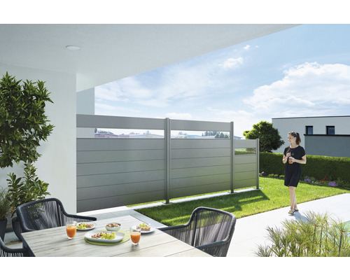 Gartenszene mit Zaunelementen, Gartentisch und Stühlen auf einer Terrasse