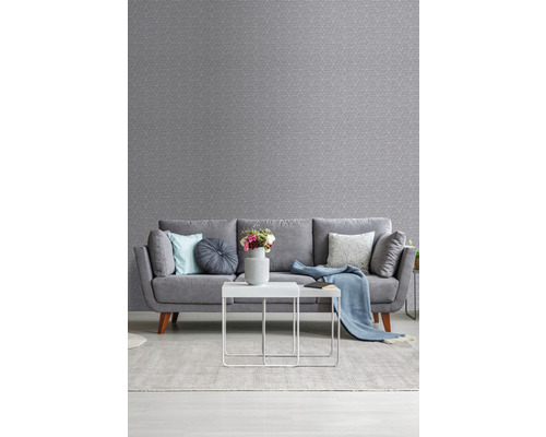 Wohnzimmer mit grauer gemusterter Tapete, Sofa, Teppich und Tisch