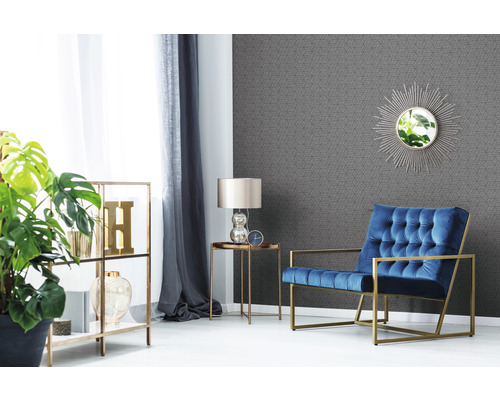 Wohnzimmer mit Sessel, Regal, Lampe und geometrischer Tapete
