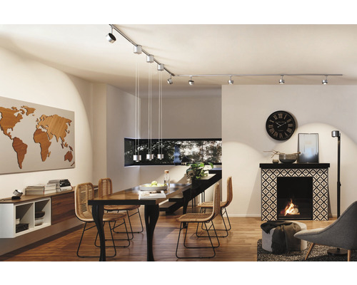 Esszimmer mit Esstisch, Stühlen, Kamin, Weltkarte und Schienensystem mit Strahlern