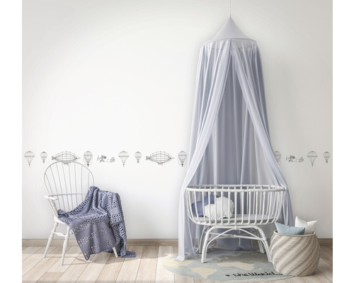 Babyzimmer mit Wandbordüre, Himmelbett und Stuhl mit Decke