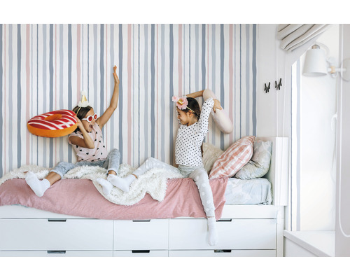 Mädchenzimmer mit gestreifter Tapete, Bett und Schubladen