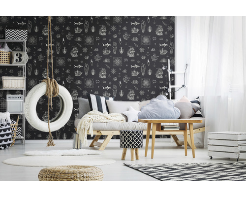 Dekoratives Zimmer mit Reifenschaukel, Couch und Tapete mit maritimen Motiven.