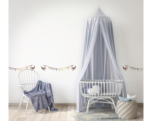 Kinderzimmer mit Himmelbett, Wiege, Stuhl, Decke und Wandtattoo mit Vogelmotiv