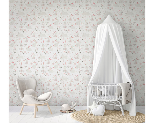 Kinderzimmer mit Hasentapete, Sessel und Babybett mit Baldachin.