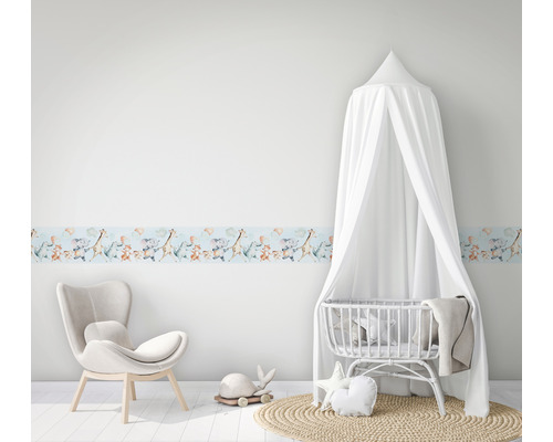 Kinderzimmer mit einer Bordüre mit Tiermotiven, einem Stuhl und einem Babybett mit Baldachin.