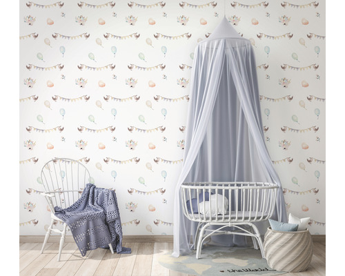 Kinderzimmer mit Babybett, Stuhl und gemusterter Tapete mit Festgirlanden und Tieren