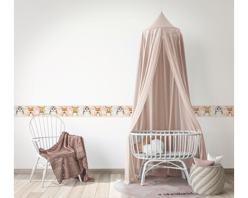 Kinderzimmer mit Tiermuster-Bordüre, Stuhl, Baldachin über Kinderbett und geflochtenem Korb
