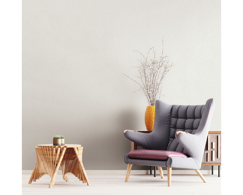 Wohnzimmer mit Sessel, Beistelltisch und dekorativer Blumenvase