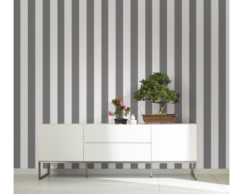 Zimmer mit gestreifter Tapete und weißem Sideboard