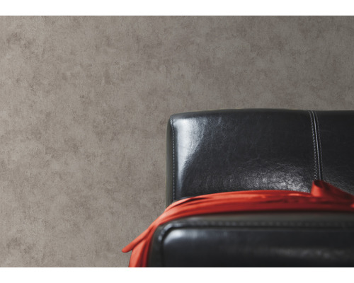 Nahaufnahme einer grauen Wand mit einem schwarzen Ledersessel und einem roten Tuch