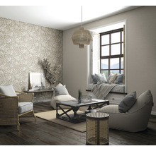 Wohnzimmer mit Rattanmöbeln, gemusterter Tapete, Fensterplatz und Holzboden für eine helle und organisierte Atmosphäre.