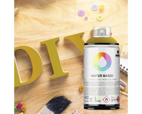 Szene mit DIY-Buchstaben, Pinsel, Schreibwaren und Sprühdose auf Wasserbasis