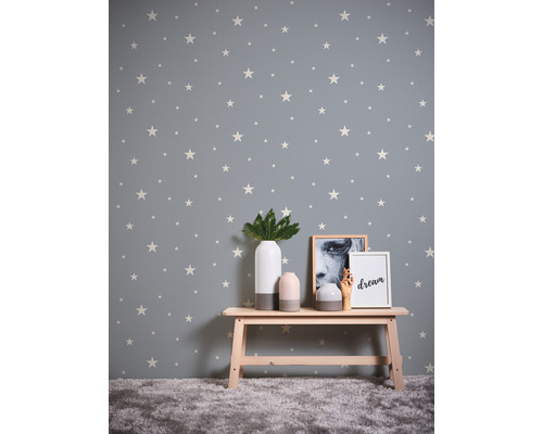 Raum mit Sternentapete, Bank und dekorativen Objekten.