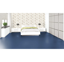 Schlafzimmer mit Bett, Nachttischen, Lampen, Schrank und blauem Bodenbelag