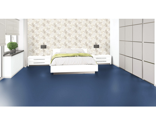 Schlafzimmer mit Bett, Nachttischen, Lampen, Schrank und blauem Bodenbelag