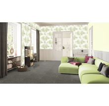 Wohnzimmer mit gemusterter Tapete, grünem Sofa und Teppich