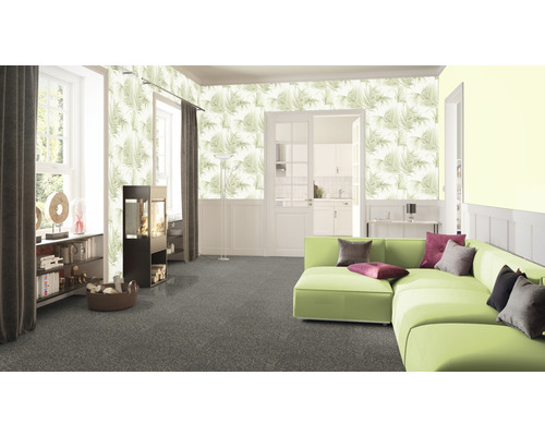 Wohnzimmer mit gemusterter Tapete, grünem Sofa und Teppich