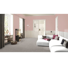 Wohnzimmer mit modernem Kaminofen, Bücherregal und weißem Ecksofa vor rosa gestrichener Wand