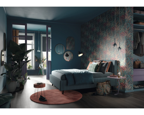 Schlafzimmer mit Bett, floraler Tapete, Spiegeln und Zimmerpflanzen