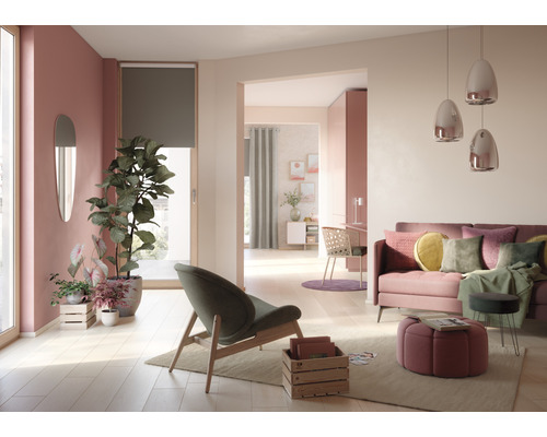 Heller Wohnraum mit Sofa, Sessel, Zimmerpflanzen und Dekoration
