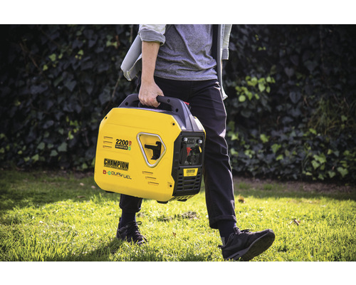 Eine Person trägt einen gelben Champion 2200 Watt Inverter Generator im Freien.