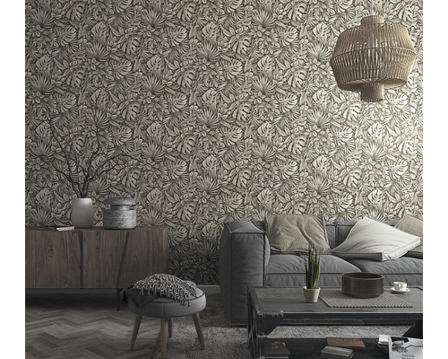 Wohnzimmer mit Couch, Tisch und mit Blättern gemusterter Tapete