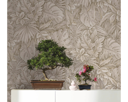 Zwei Bonsai-Bäume auf einem Schrank vor einer Wand mit Blättermuster-Tapete.