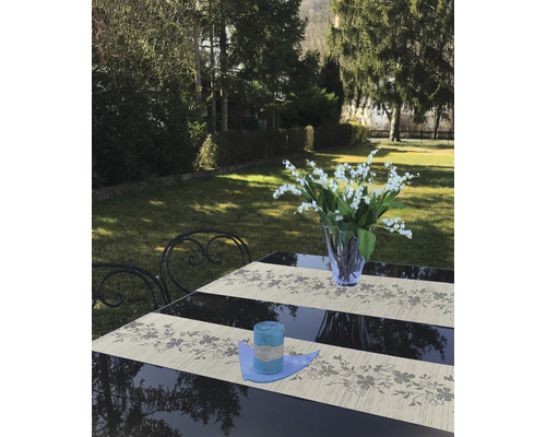 Dekorierter Gartentisch mit blauer Kerze und Blumenstrauß im Garten