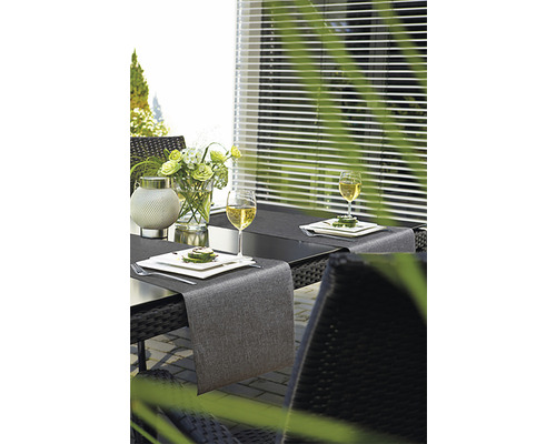 Gedeckter Gartentisch mit Tischläufer, Geschirr und Getränken für ein entspanntes Essen im Freien