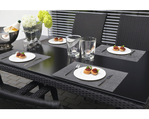 Gedeckter Gartentisch mit Speisen, Getränken und Dekoration für ein Essen im Freien.