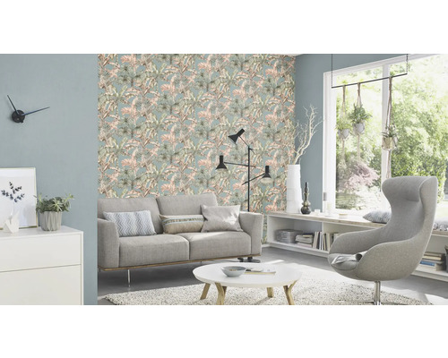 Wohnzimmer mit gemusterter Tapete, Sofa, Sessel und Dekoration
