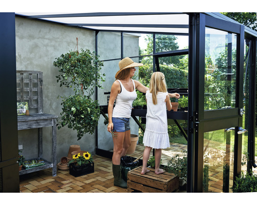 Gewächshaus mit Mutter und Tochter beim Gärtnern, helle und freundliche Atmosphäre